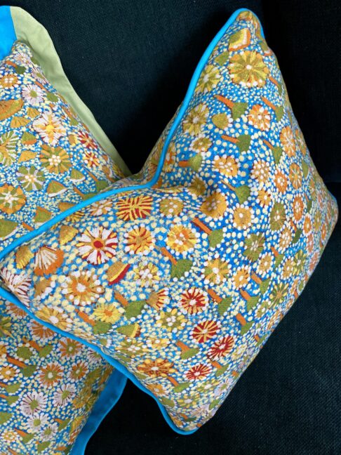 Small lumbar cushion in turquoise, green and yellow floral indigenous Aboriginal art print. Linen fabric with turquoise cotton piping.