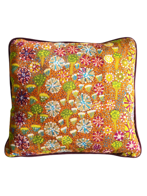 Lumbar mini-cushion with colourful, botanical, Aboriginal art print in orange with burgundy trim.