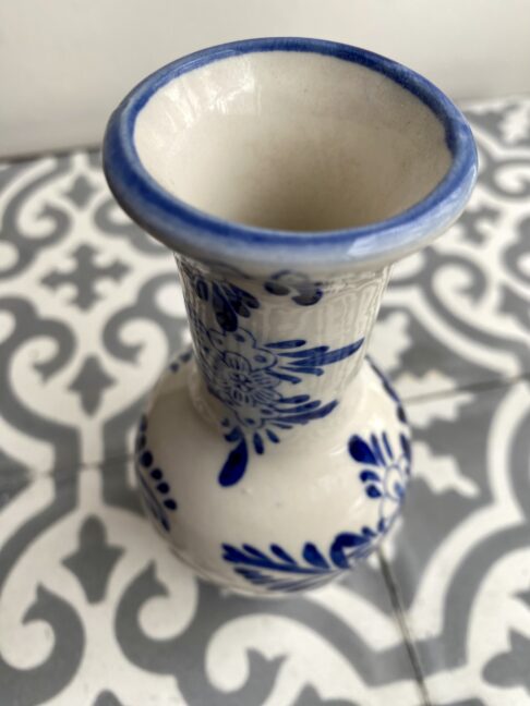 Neck and rim detail of a blue and white Dutch Delft bud vase.