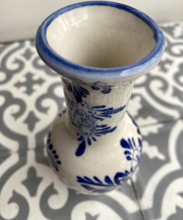 Neck and rim detail of a blue and white Dutch Delft bud vase.