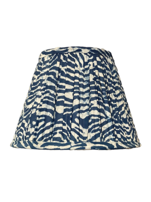 An indigo, gathered-cotton lampshade with a block-printed wave design.