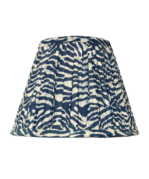 An indigo, gathered-cotton lampshade with a block-printed wave design.