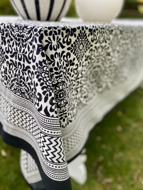 Close up of a Mughal-style pattern on a black and white block-print cotton tablecloth.