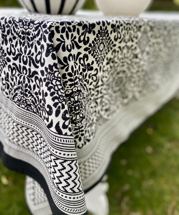 Close up of a Mughal-style pattern on a black and white block-print cotton tablecloth.