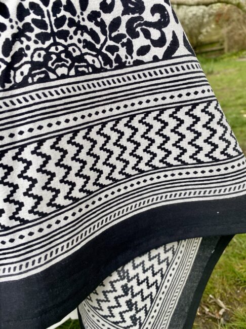 Detail of a geometric border on a black and white block-printed tablecloth.