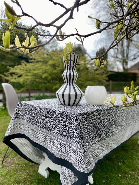 A smart, outdoor dining setting is dressed with a bold, black and white block-print tablecloth.