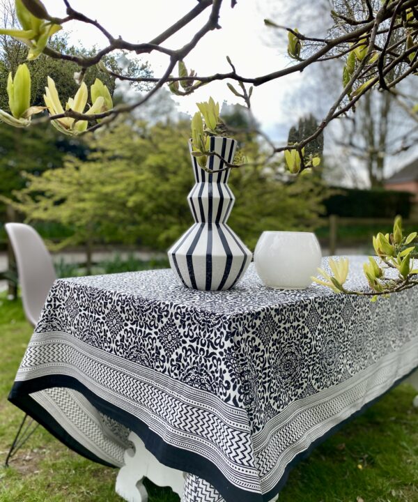 A smart, outdoor dining setting is dressed with a bold, black and white block-print tablecloth.