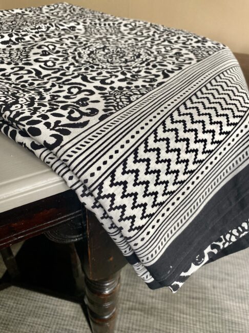 Black and white block-print cotton tablecloths with a striped border.