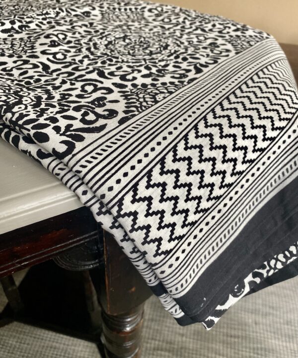 Black and white block-print cotton tablecloths with a striped border.