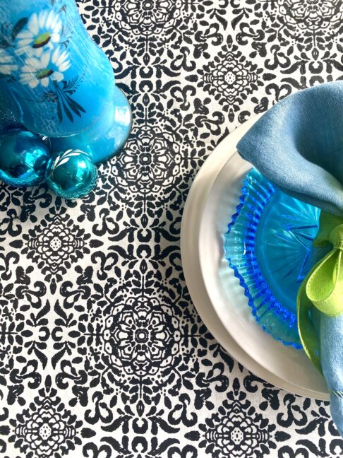 Block-print-cotton tablecloths for a festive table. Black and white pattern underscores a turquoise blue table setting.