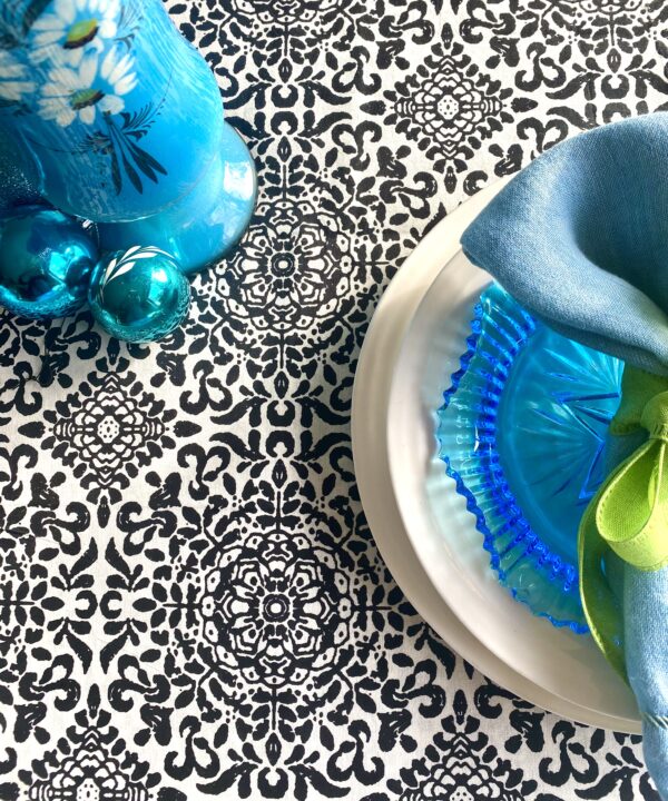 Block-print-cotton tablecloths for a festive table. Black and white pattern underscores a turquoise blue table setting.