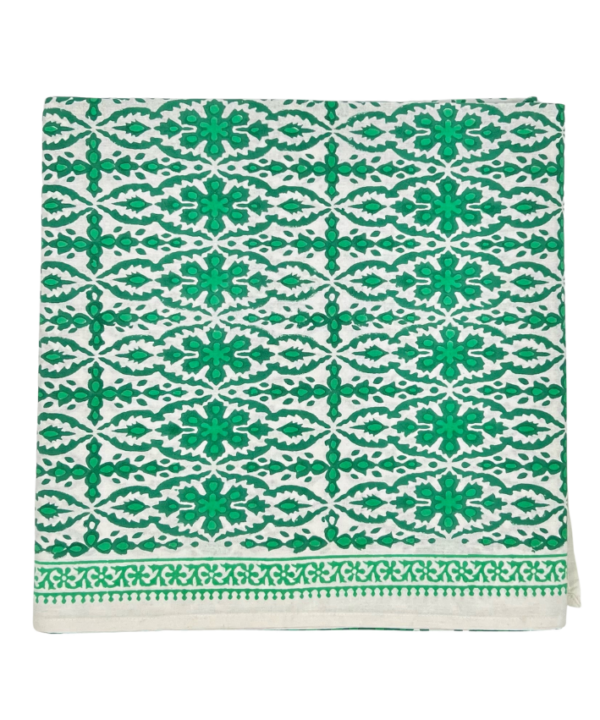 Vibrant, block-print green tablecloth with a decorative border.