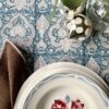 Beautiful blue block print tablecloths on a festive table with vintage French crockery, eucalyptus and mirrored baubles.