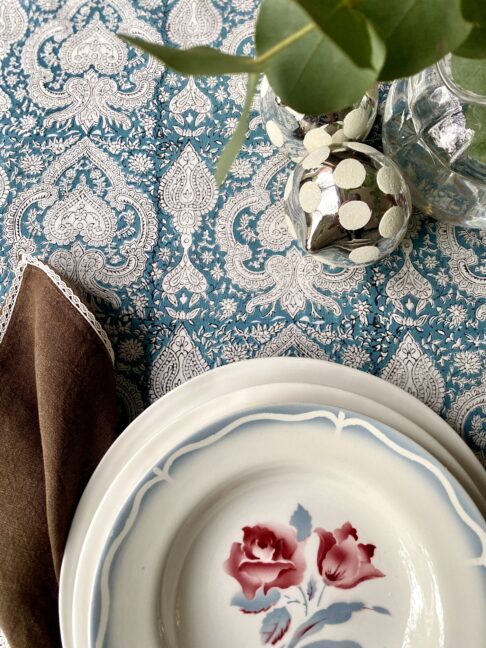 Beautiful blue block print tablecloths on a festive table with vintage French crockery, eucalyptus and mirrored baubles.