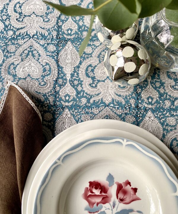 Beautiful blue block print tablecloths on a festive table with vintage French crockery, eucalyptus and mirrored baubles.