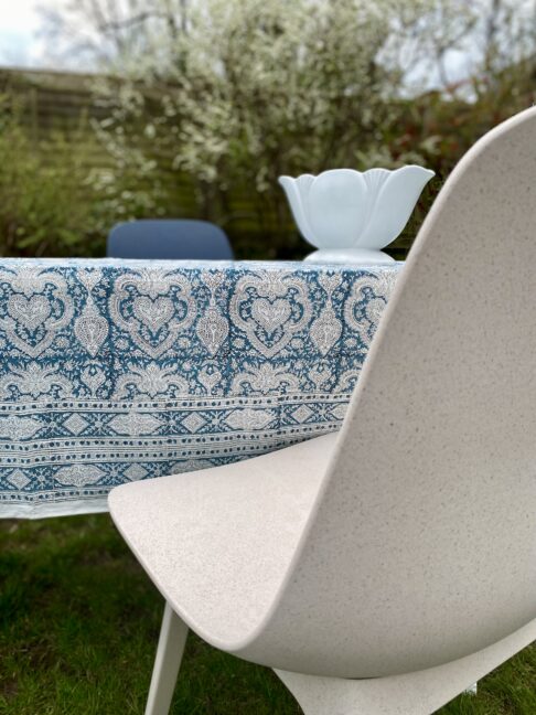 Pretty, blue tablecloths in a traditional, Indian block-print look smart teamed modern chairs in an outdoor dining setting.