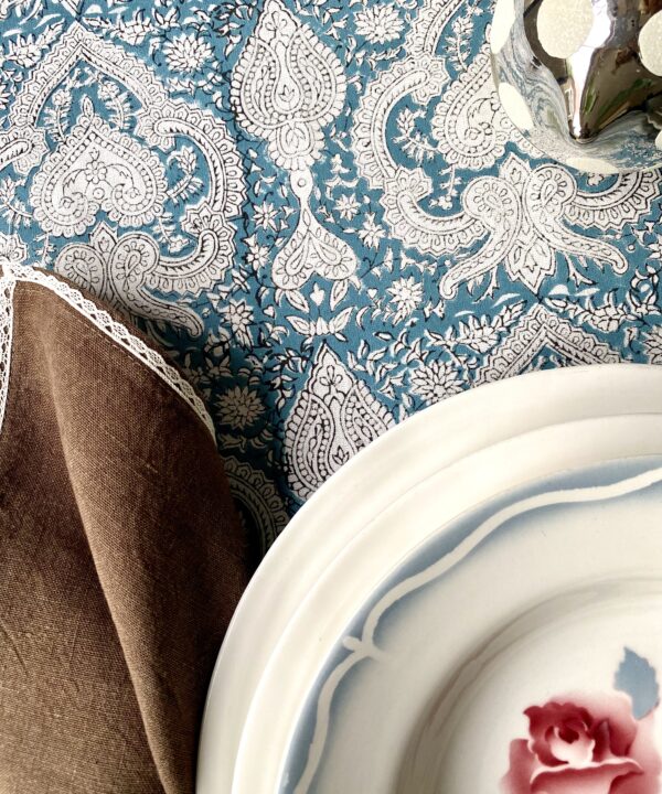 Blue Mughal patterned tablecloth detail on a festive table.