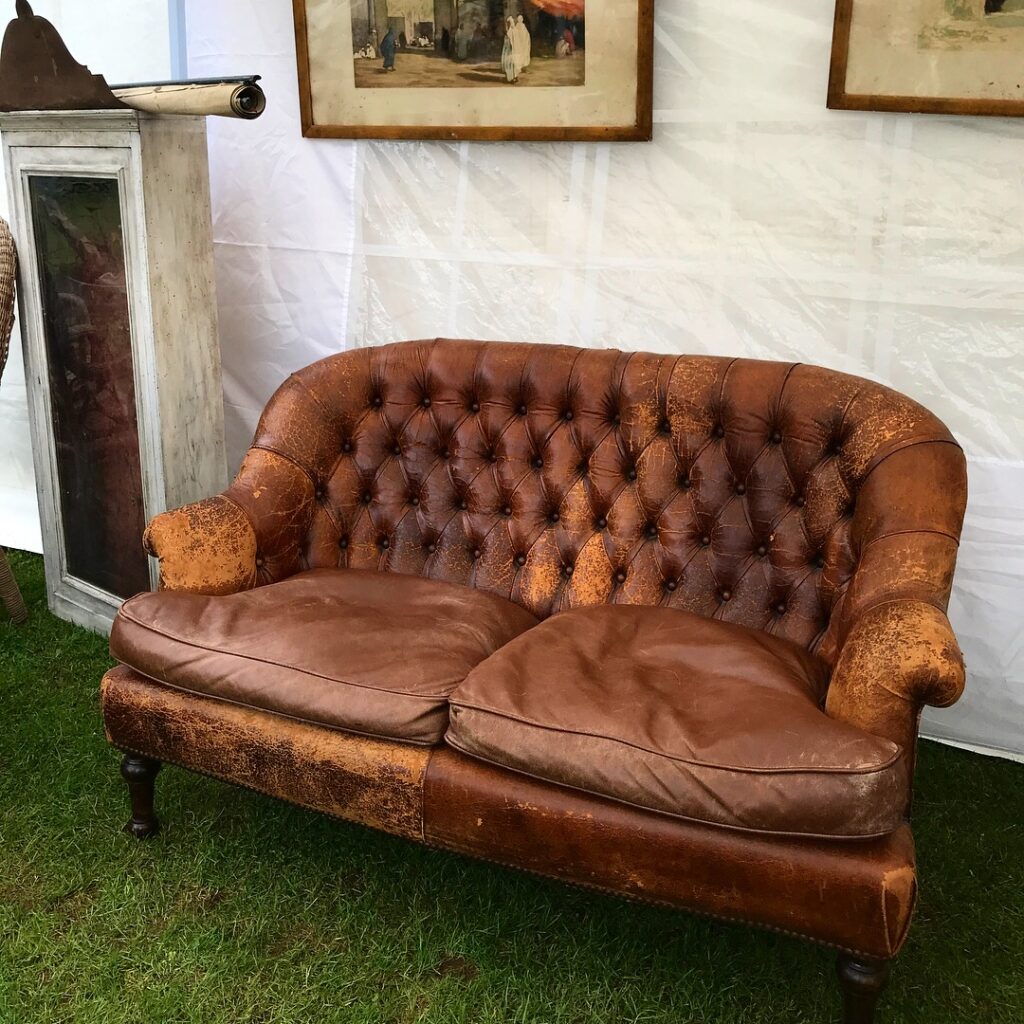 A petite, vintage, buttoned-leather sofa in perfectly distressed tan.