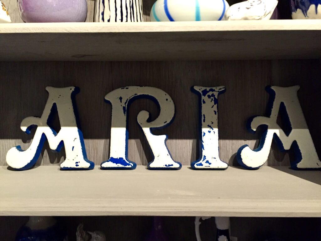 Vintage French shop front letters are re-arranged to spell out the word Aria.