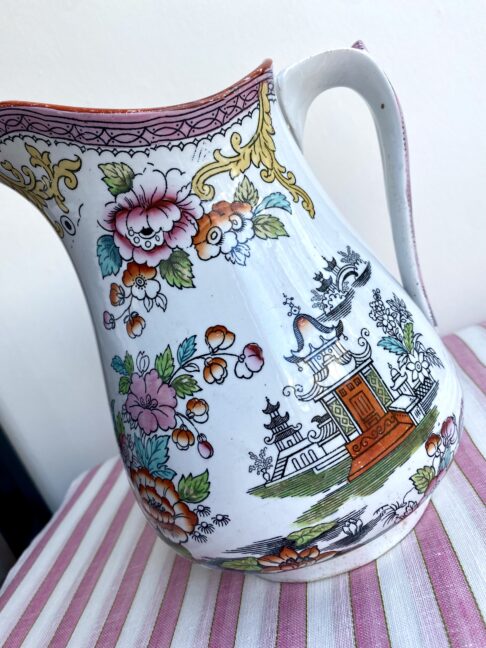 Temples and roses on a vintage jug in pink and orange.