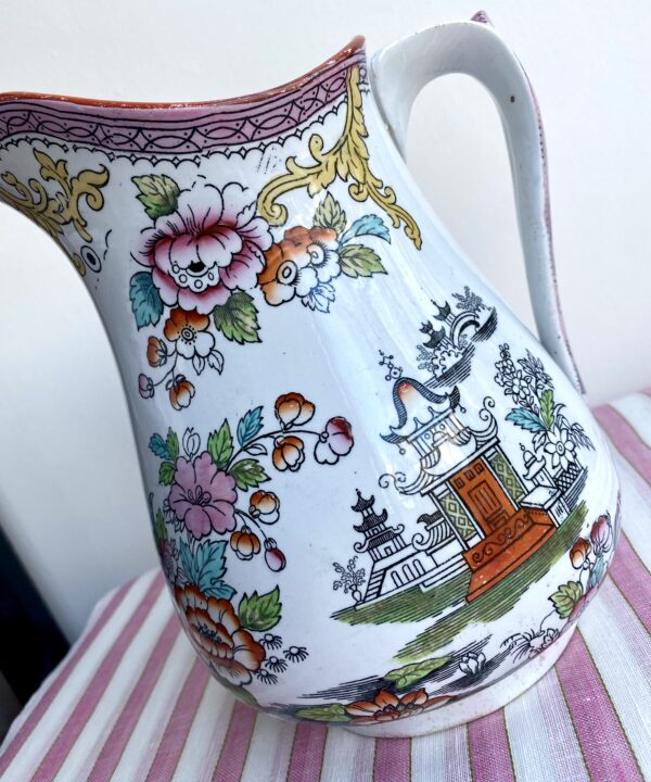 Temples and roses on a vintage jug in pink and orange.