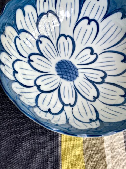 Detail of a vintage bowl with a bold, indigo, Japanese floral design.