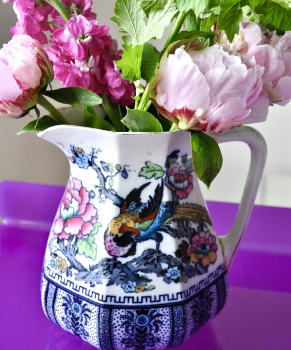 Vintage jugs for flowers. Losolware 'Shanghai' jug filled with roses and peonies on a purple Perspex side table.