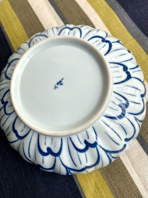 A Japanese back stamp on a vintage Japanese pottery bowl in indigo and denim blue.