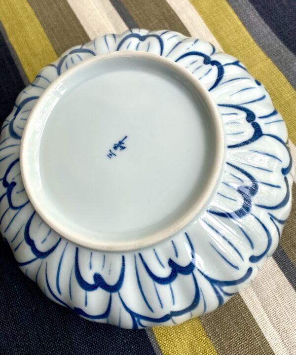 A Japanese back stamp on a vintage Japanese pottery bowl in indigo and denim blue.