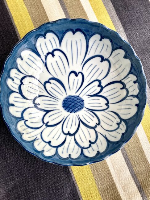 A beautiful bowl from Japan displayed on a stripy linen tablecloth.