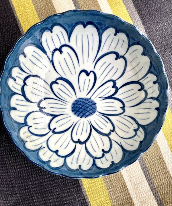 A beautiful bowl from Japan displayed on a stripy linen tablecloth.