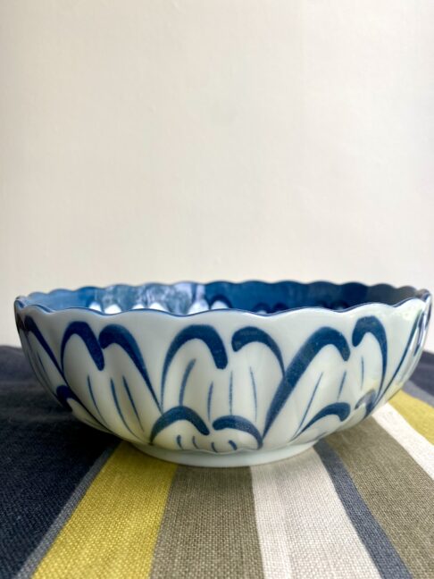 A scalloped bowl with giant floral decoration inside and out.