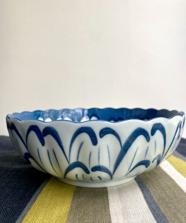 A scalloped bowl with giant floral decoration inside and out.