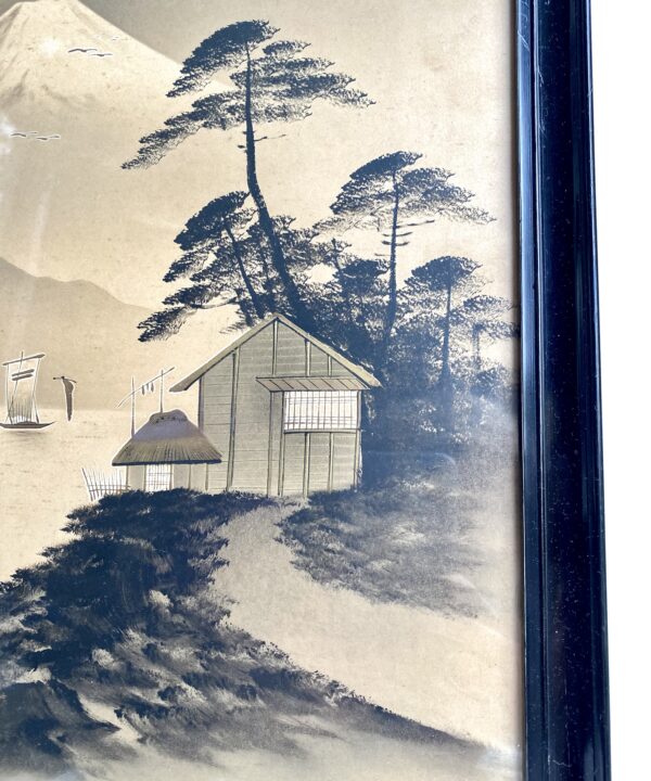 Close-up of a Japanese landscape print depicting trees and a gold-accented hut in the foreground.