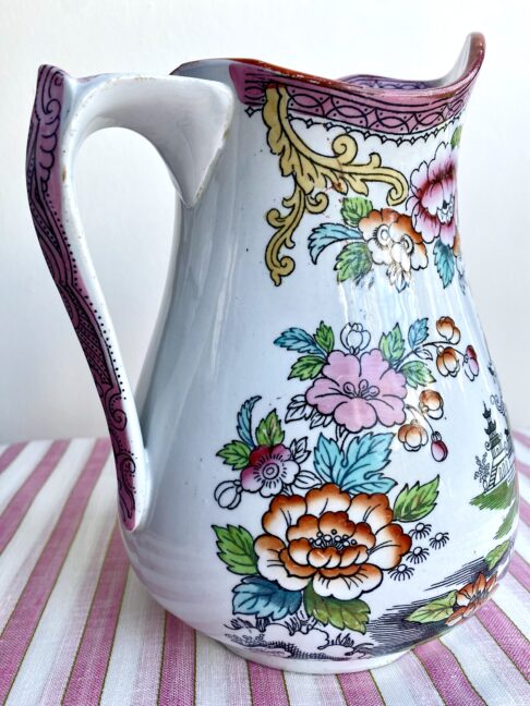 Up close, the detail of flowers and a Chinese landscape, on a vintage pitcher.