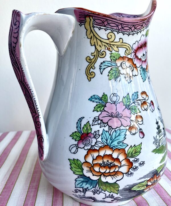 Up close, the detail of flowers and a Chinese landscape, on a vintage pitcher.