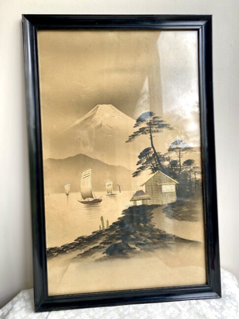 Vintage Japanese landscape art with gold accents and framed in black.