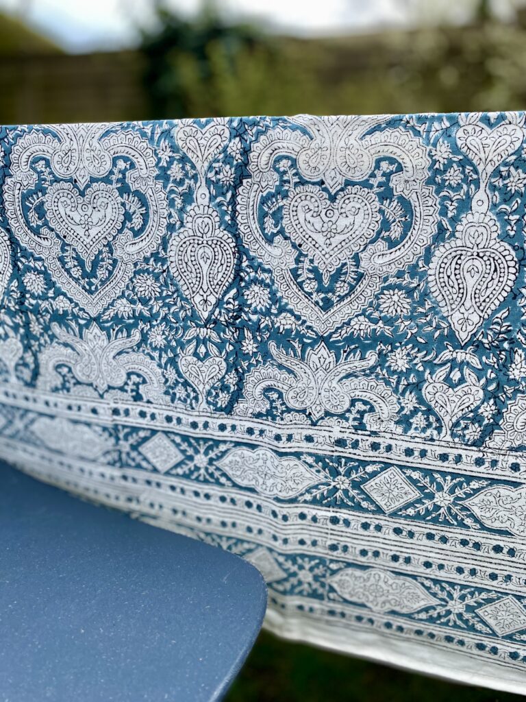 An Indian-block-printed, blue, paisley tablecloth in lightweight cotton.