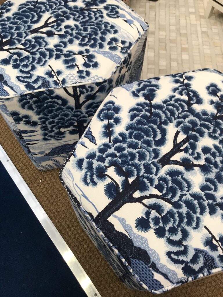 A pair of hexagonal upholstered stools by Robert Langford in a blue and white botanical print.