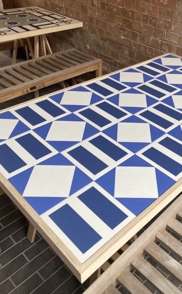 A Royal blue and white, geometric-tiled table by Domus Design.