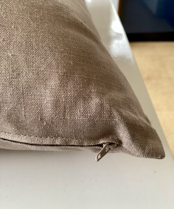 Zip detail on a taupe, glazed and brushed linen cushion.