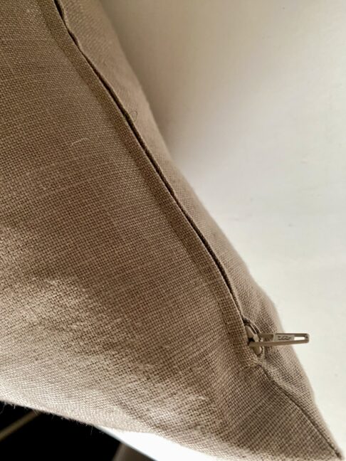 Zip detail on a taupe linen cushion made from vintage fabric.