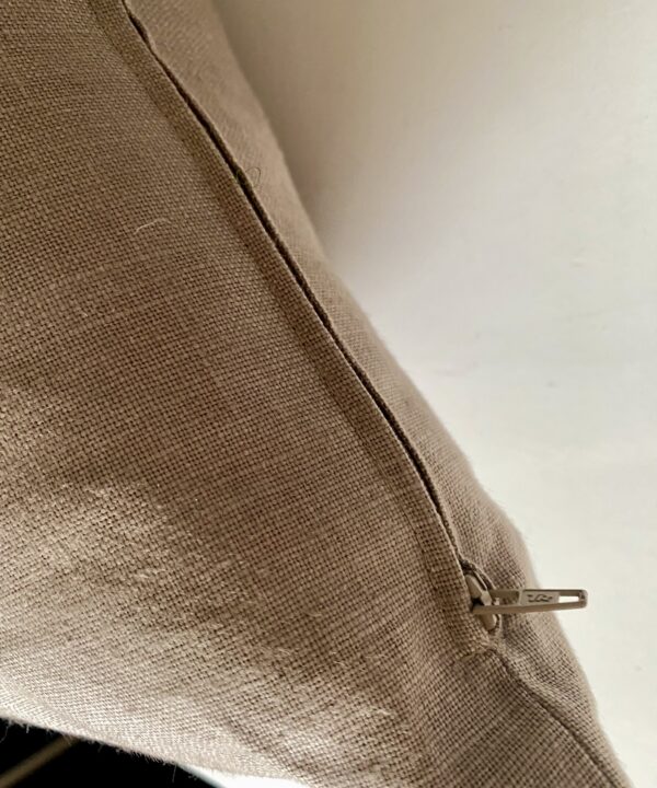 Zip detail on a taupe linen cushion made from vintage fabric.