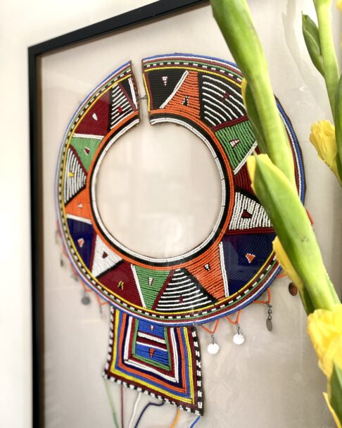 Close-up shot of a beaded Maasai collar necklace, framed as wall art.