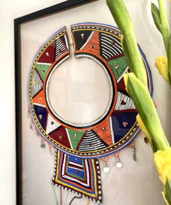 Close-up shot of a beaded Maasai collar necklace, framed as wall art.