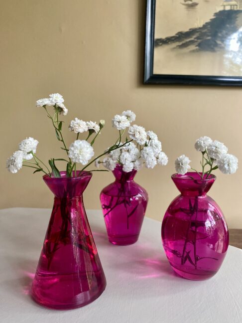 A trio of hot pink glass bud vases.