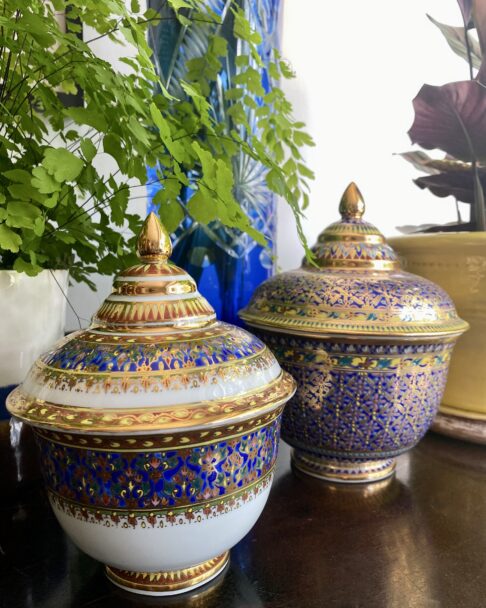 Two elegant Benjarong pots from Thailand in blue, yellow and gold and intricately decorated by hand.