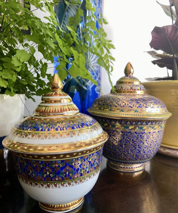 Two elegant Benjarong pots from Thailand in blue, yellow and gold and intricately decorated by hand.