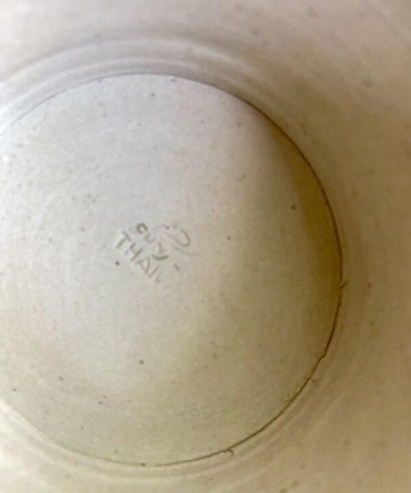 The Thai back stamp on a ceramic, footed dish.