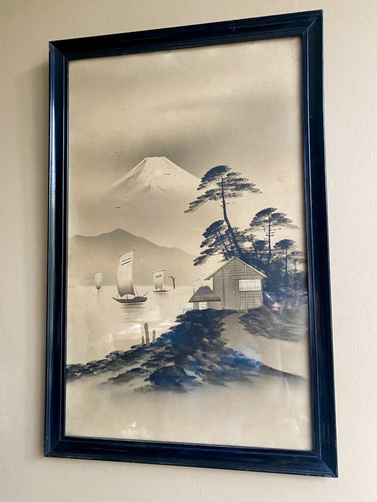 A vintage Asian - probably Japanese - landscape print in warm beige with gold accents.